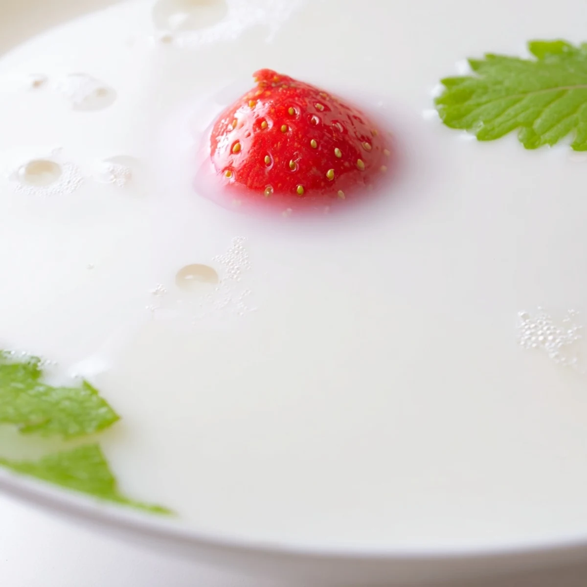 Smooth Japanese strawberries and milk yokan dessert sliced into servings with mint garnish