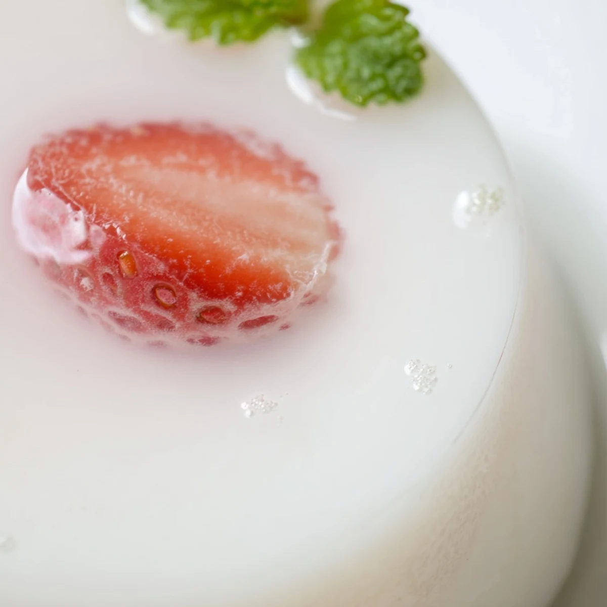 Soft gelatinous milk yokan dessert featuring suspended strawberry halves ready for spring serving