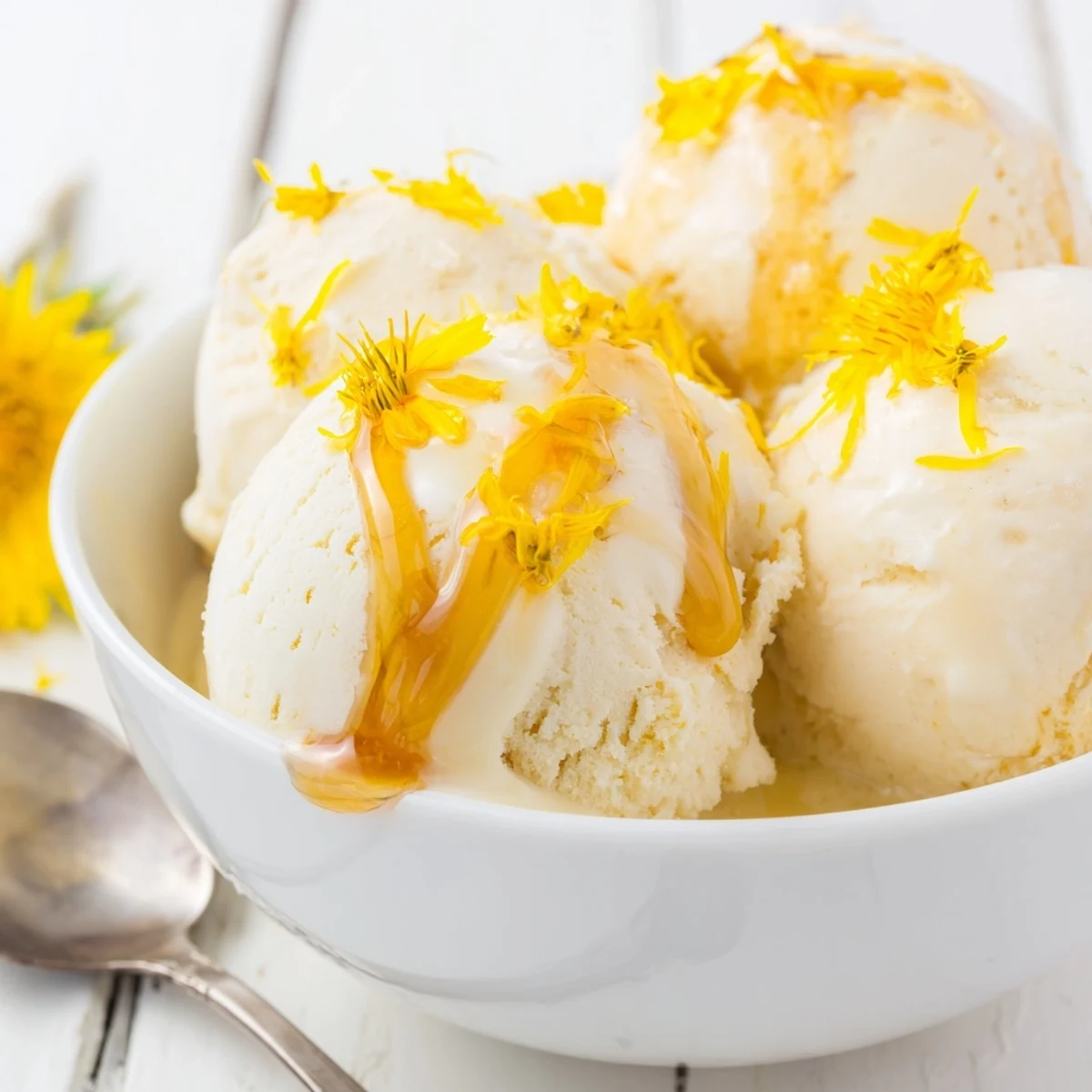 Homemade dandelion honey ice cream in a chilled bowl with floral garnish