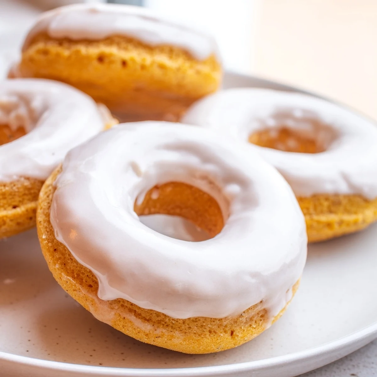 Golden baked Greek yogurt cake donuts topped with sweet vanilla glaze and sprinkles