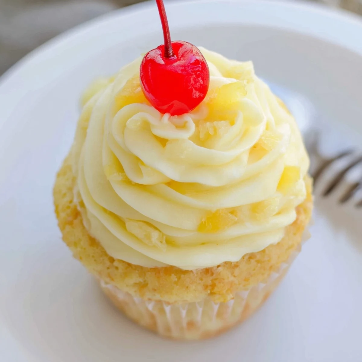 A dozen tropical Dole Whip Cupcakes with pillowy frosting and fresh pineapple wedges