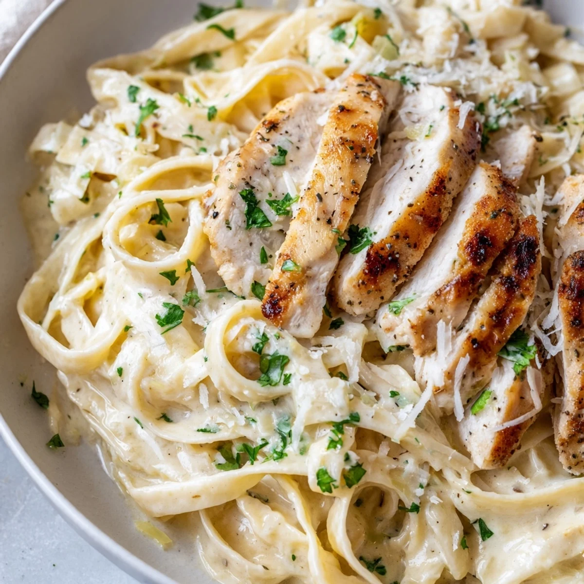 Sliced Creamy Garlic Chicken Pasta tossed in silky sauce, Parmesan snow