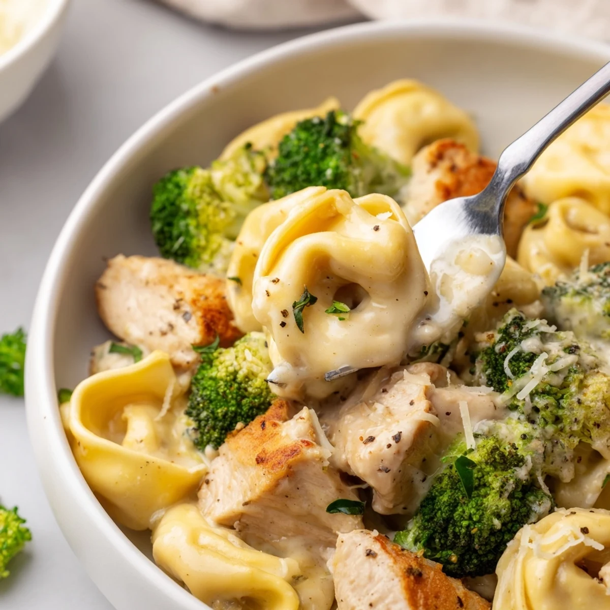 Hearty Creamy Garlic Parmesan Tortellini Chicken Broccoli Recipe topped with extra grated Parmesan  