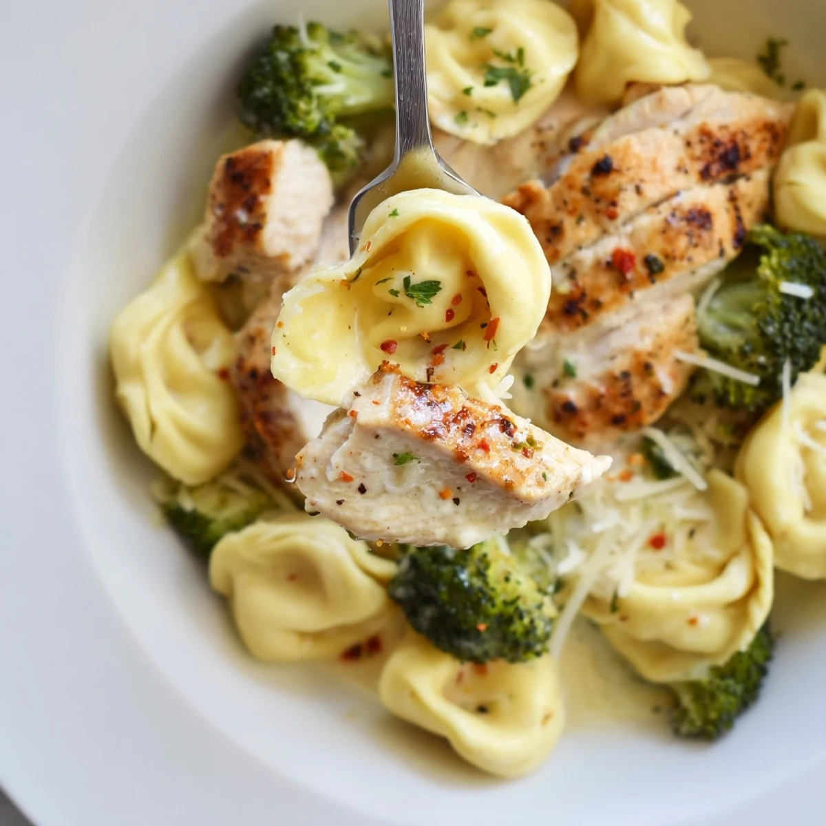 Family-style Creamy Garlic Parmesan Tortellini Chicken Broccoli Recipe plated beside crusty bread