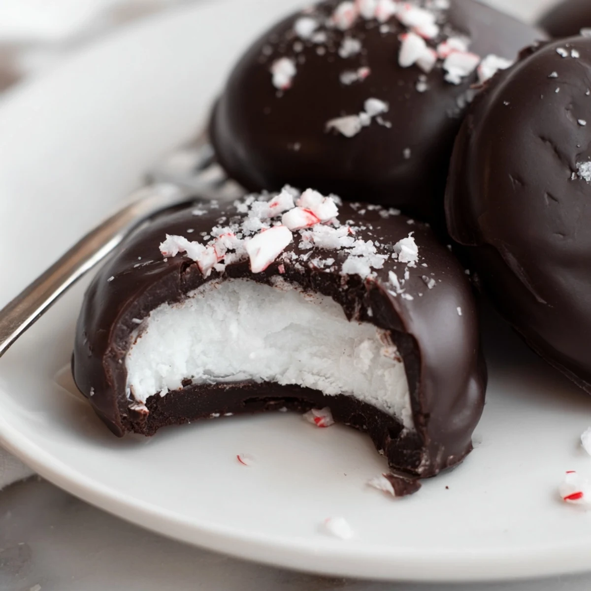 Homemade Peppermint Patties with glossy dark chocolate, chilled on parchment.
