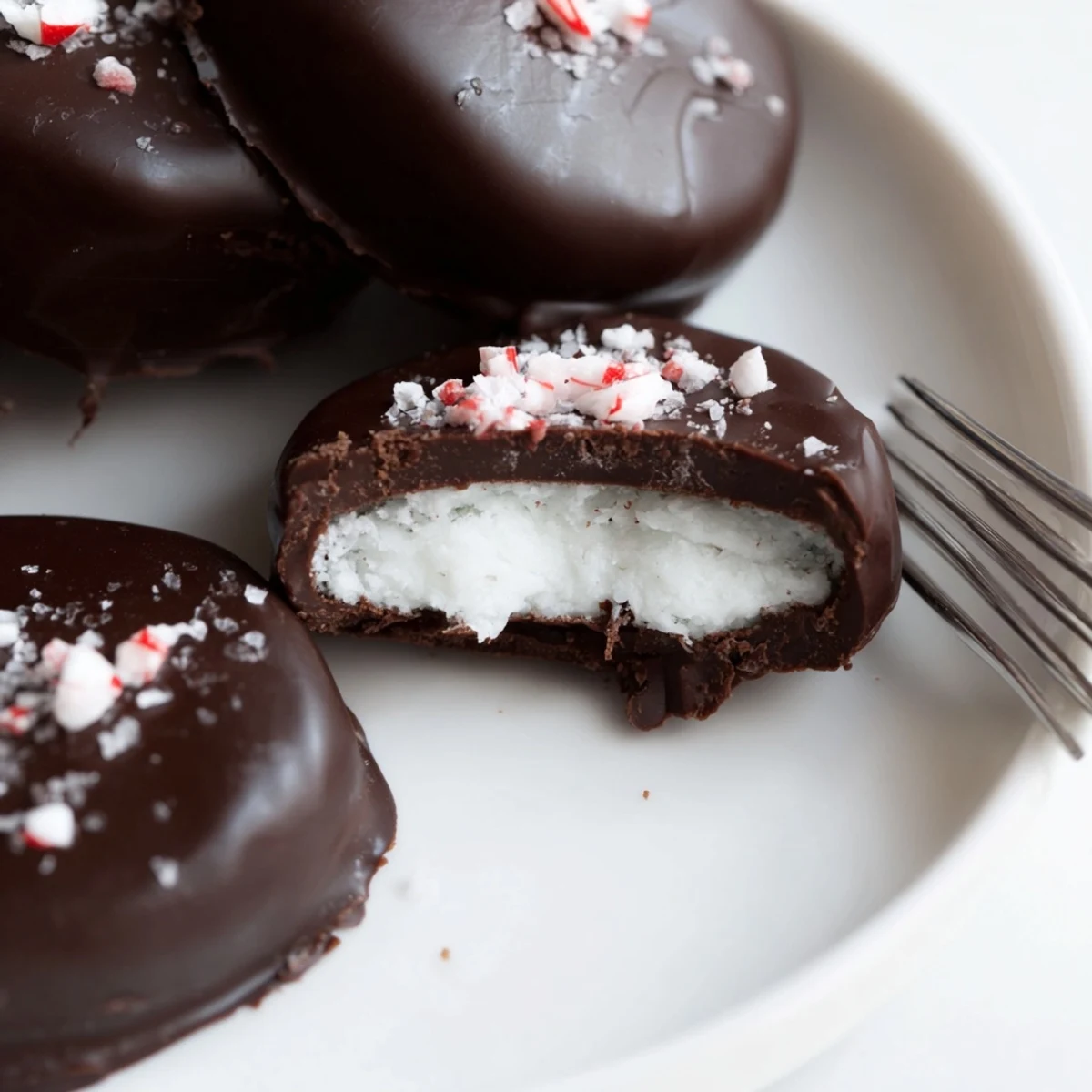 Fork-dipped Peppermint Patties resting on cooling rack, smooth mint center.