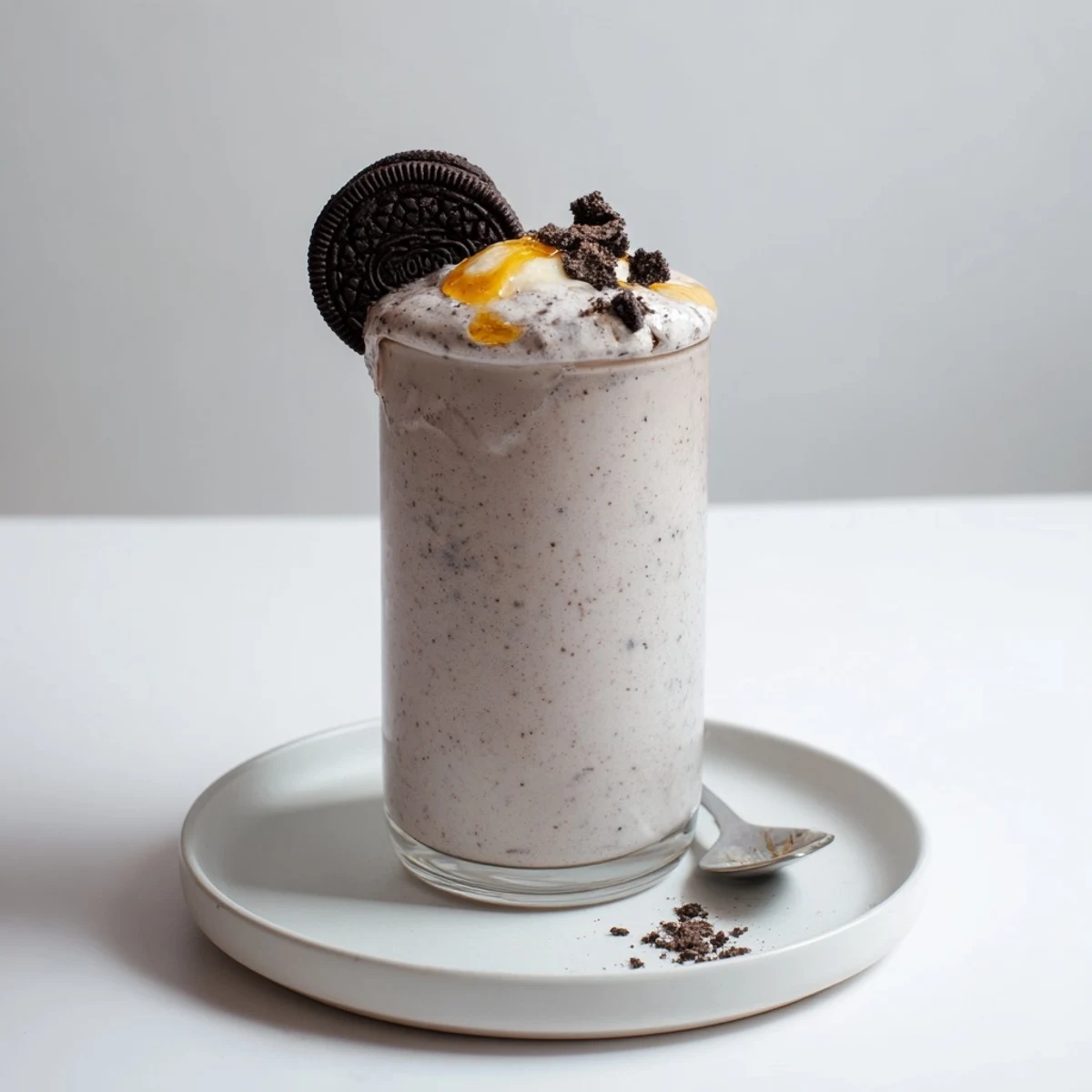 Cold Cookies And Cream Protein Shake in tall glass, frothy and creamy