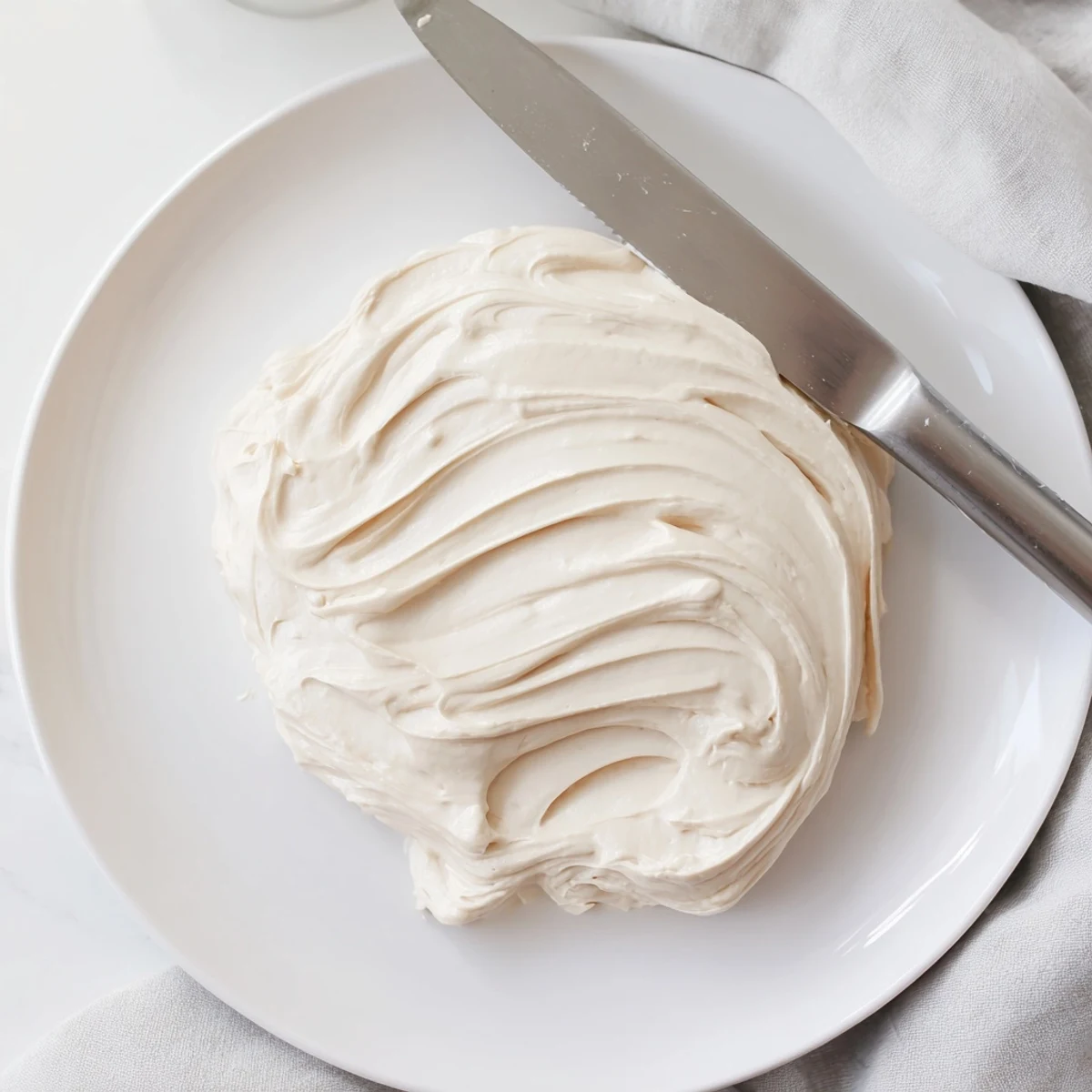 Creamy Italian Meringue Buttercream swirled atop a golden layer cake