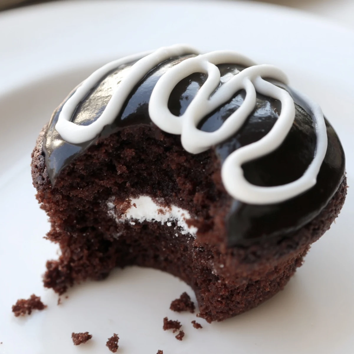 Moist chocolate Homemade Hostess Cupcakes drizzled with rich ganache and classic white icing swirl