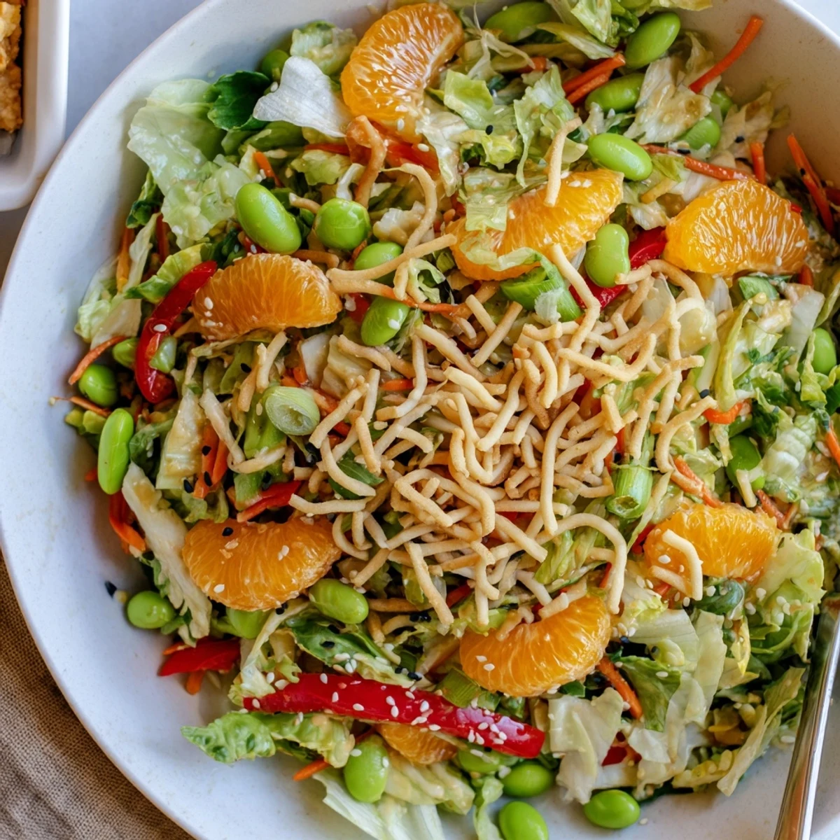 Fresh Mandarin Sesame Crunch Salad served on a platter with vibrant greens shredded carrots and crunchy toppings